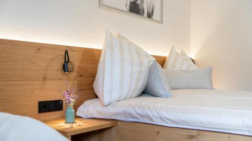 a bed with white pillows on it in a room at Ferienwohnung Zweite Heimat in Mieders
