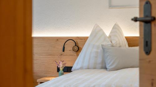 a bedroom with a bed with white pillows and a clock at Ferienwohnung Zweite Heimat in Mieders