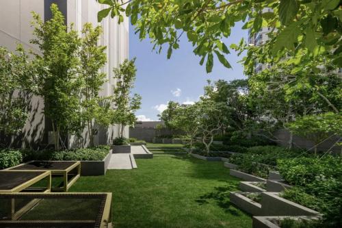 an internal courtyard of a building with benches and trees at Vacaystation Edge Central Pattaya in Pattaya Central