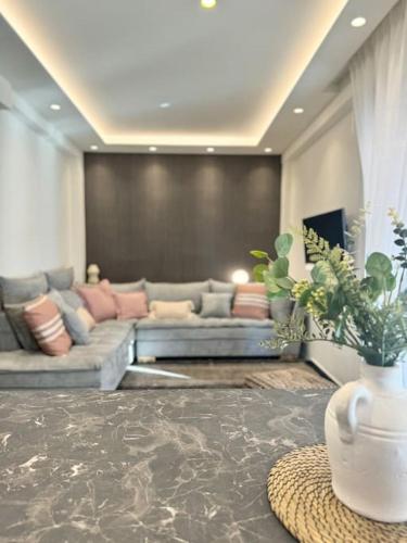 a living room with two couches and a table at R&G luxury accommodation Varkiza in Vari