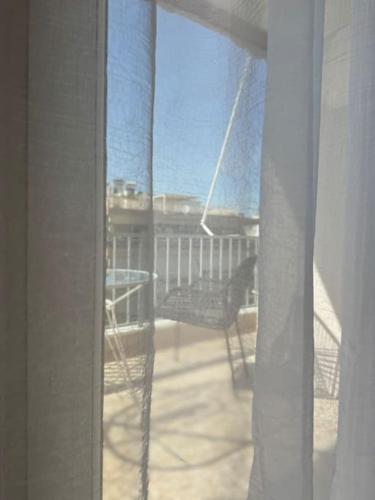a view of a balcony with a table and a chair at R&G luxury accommodation Varkiza in Vari
