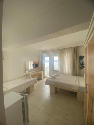 a large room with two beds and a television at Simsek Hotel in Fethiye