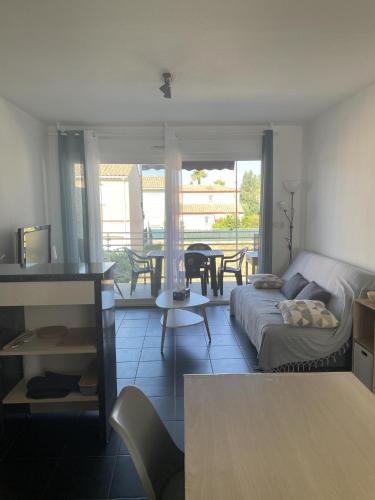 un salon avec un canapé et une table dans l'établissement St Cyprien T2 3 etoiles lumineux a 200m de la plage, à Saint-Cyprien