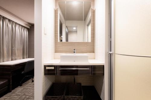 東京にあるUrvest Hotel Kamataの洗面台と鏡のあるバスルーム