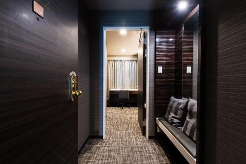 a hallway with a door leading to a room at Urvest Hotel Kamata in Tokyo