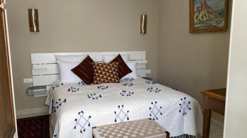 a bedroom with a large white bed with blue flowers on it at villazancot in Tangier