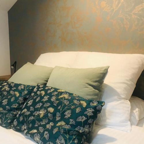 a bed with two pillows on top of it at La Curiosité, Et Pop Et Chic ! in Poitiers