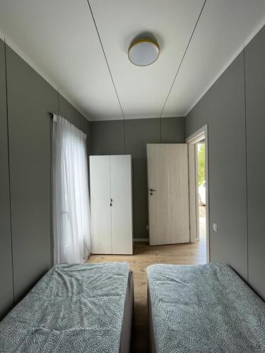 una camera da letto con due letti e uno specchio di Jaukus Namelis Šventojoje a Palanga