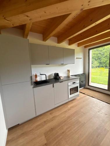 une cuisine avec des appareils blancs et une grande fenêtre dans l'établissement Logement route de vins, à Bœrsch