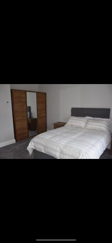 a bedroom with a white bed and a mirror at Brand New home in Dungloe in Donegal