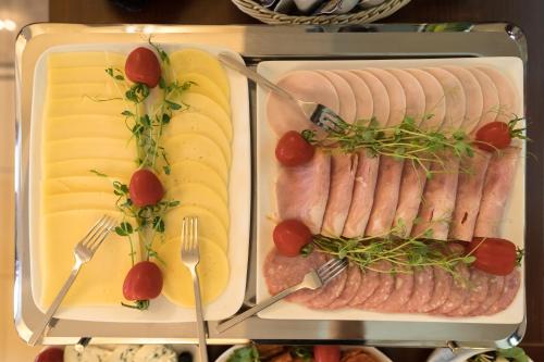 a refrigerator filled with meats and cheese and forks at HOTEL I RESTAURACJA BROCHÓW in Wrocław