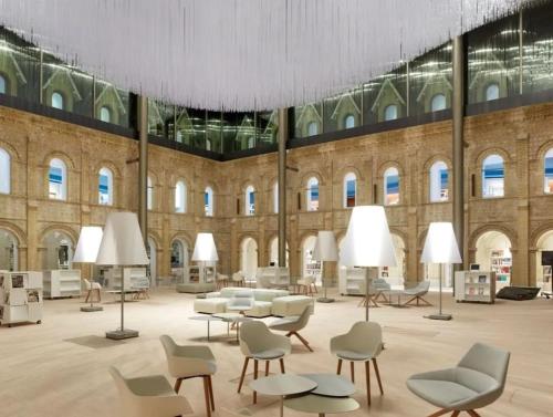 une grande chambre avec des chaises et des tables dans un bâtiment dans l'établissement Joli studio Deauville, à Deauville