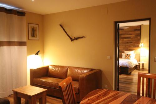 a living room with a leather couch and a bed at Nosy Manga - Hotel Ivato Airport in Antananarivo