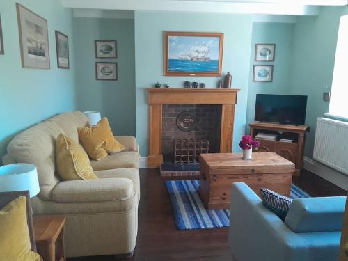 a living room with a couch and a fireplace at The Captain's House Charlestown St Austell in Charlestown