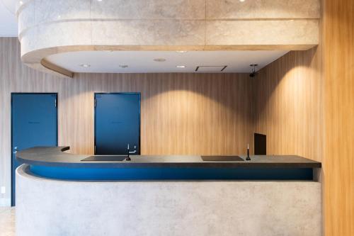 a lobby with a counter with two blue doors at Urvest Hotel Kamata in Tokyo