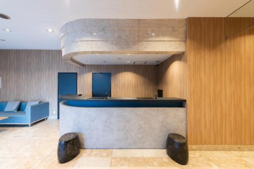 a lobby with a counter and a blue couch at Urvest Hotel Kamata in Tokyo