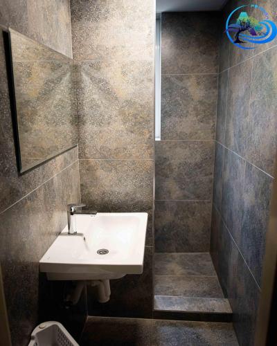 a bathroom with a sink and a tiled wall at Penzion Anička in Klokočov