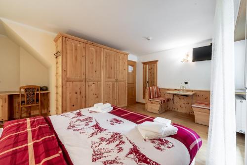 a bedroom with a large bed and a sink at Hotel Villetta Maria Cottage in Canazei