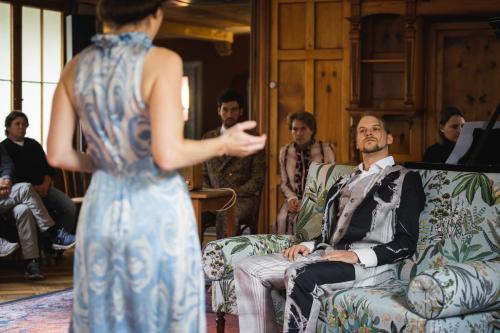 a woman standing next to a man sitting on a couch at Post Hotel Löwe Mulegns in Mühlen