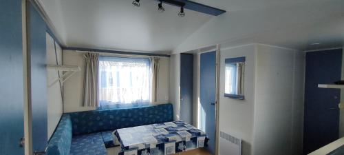 een kamer met een blauwe bank en een raam bij Camping Le Logis 3 étoiles in Saint-Jean-de-Monts
