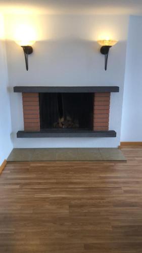 a fireplace in a living room with two lights on at Ferientraum direkt am Thunersee in Sigriswil