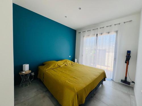 - une chambre avec un lit jaune et un mur bleu dans l'établissement Villa KAÏS, à Lecci