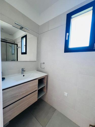 une salle de bain avec un lavabo et un miroir dans l'établissement Villa KAÏS, à Lecci