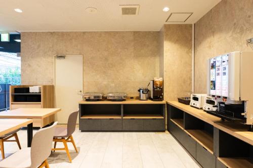 東京にあるUrvest Hotel Kamataの部屋の中にテーブルと椅子のあるキッチン