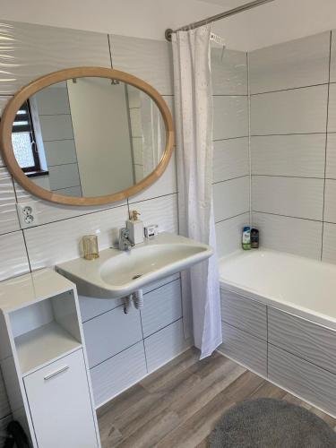 クルジュ・ナポカにあるVilla green forestの洗面台、鏡、浴槽のあるバスルーム