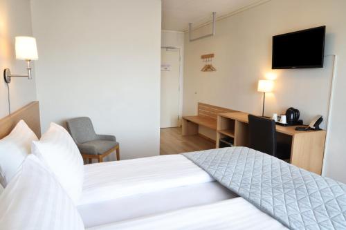 a hotel room with a bed and a desk at Fosshotel Nupar in Kálfafell