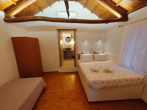a bedroom with a large bed with a wooden ceiling at Skopelos Mortero Cottage in Panormos Skopelos