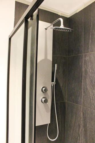 une douche dans une salle de bain avec une pomme de douche dans l'établissement Hollywood, moderne, central, à 10 min des plages, à Antibes