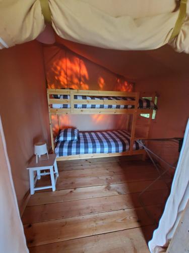 Ce lit superposé se trouve dans un dortoir doté d'une table. dans l'établissement Tente Belle vue, à Rouffignac-Saint-Cernin-de-Reilhac