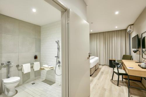 a bathroom with a toilet and a shower and a sink at Cresta Mahalapye Hotel in Mahalapye