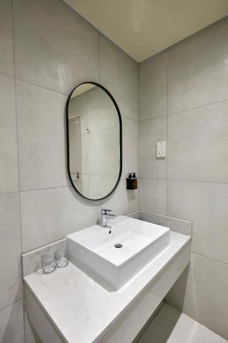 a white bathroom with a sink and a mirror at Cresta Mahalapye Hotel in Mahalapye