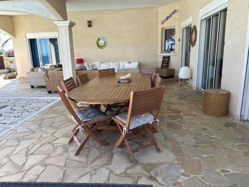 a wooden table and chairs on a patio at VILLA POINTE DES CHATEAUX VUE IMPRENABLE in Saint-Leu