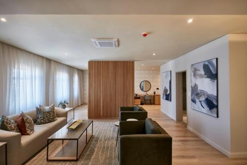 a living room with a couch and two chairs at Cresta Mahalapye Hotel in Mahalapye
