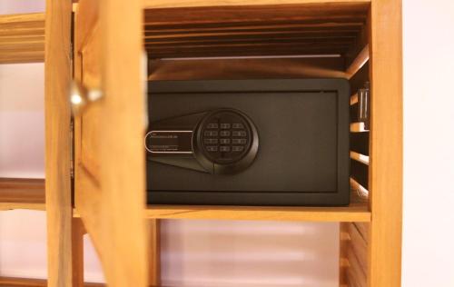 a microwave in a wooden cabinet with at Nosy Manga - Hotel Ivato Airport in Antananarivo