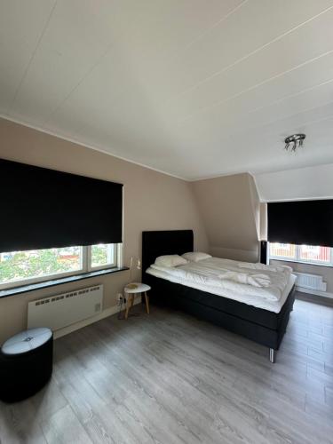 a bedroom with a large bed and two windows at Ullångers Hotell & Restaurang in Ullanger