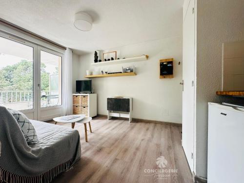 un salon avec un canapé et une télévision dans l'établissement Le Sable d'Or - Appartement coeur de ville, à Saint-Palais-sur-Mer