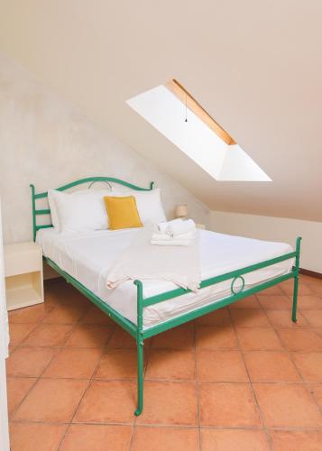 a green bed in a room with a skylight at Vila Perast Boutique Hotel in Perast