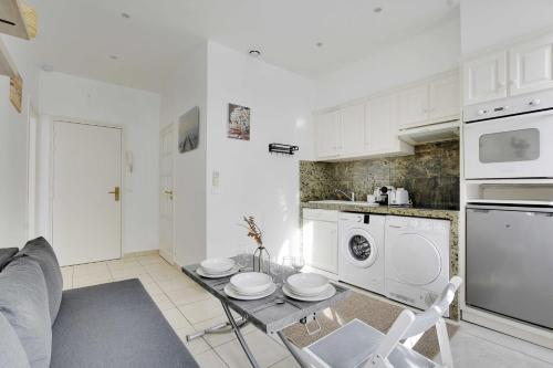 - une cuisine blanche avec une table et un four micro-ondes dans l'établissement Cozy apartment - 1BR-3P - Gare du Nord, à Paris