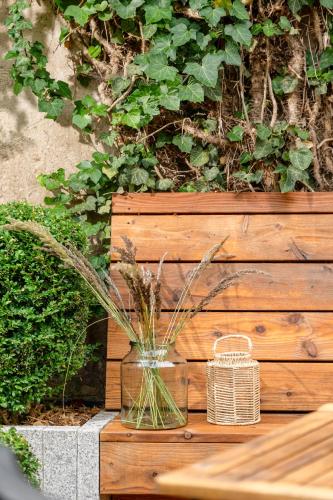 a vase with grass in it sitting on a wooden bench at Apartments an Sankt Marien in Stralsund