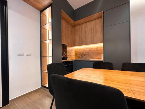 a dining room with a wooden table and black chairs at Aral Apartments - Shengjin City Gate in Shëngjin