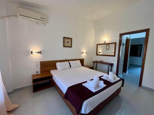 a hotel room with a bed and a mirror at Sirtaki-Siviri Apartments in Siviri
