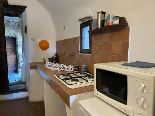 a kitchen with a microwave and a stove at Mountains' View by Holiday World in Baiardo