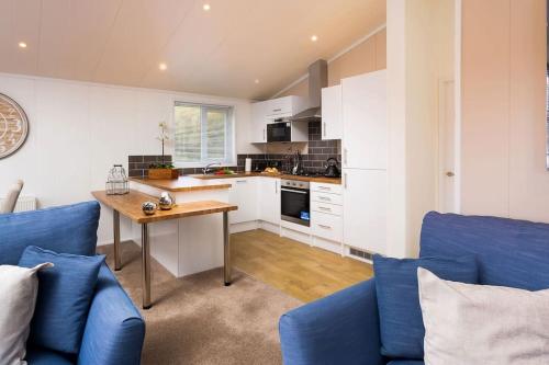 a kitchen with a blue couch and a table at Driftwood Lodge - South Lakeland Leisure Village in Carnforth