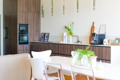 - une cuisine avec une table blanche et des chaises blanches dans l'établissement Spacieux appartement avec vue magnifique sur la baie des Sables d'Olonne - 8 personnes, à Les Sables-dʼOlonne