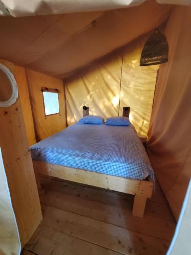 - un lit dans une petite pièce dans une tente dans l'établissement Tente des bois, à Rouffignac-Saint-Cernin-de-Reilhac