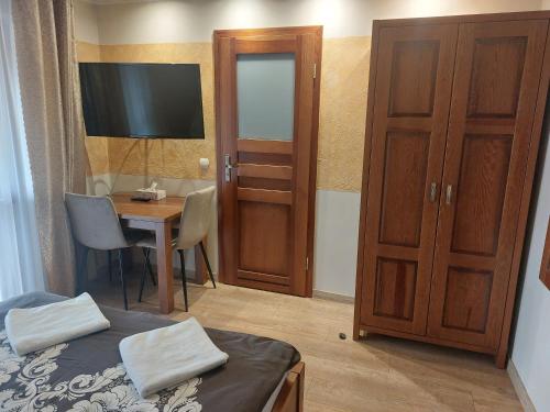 a bedroom with a bed and a desk and a television at Agroturystyka Żubrówka in Żubrówka